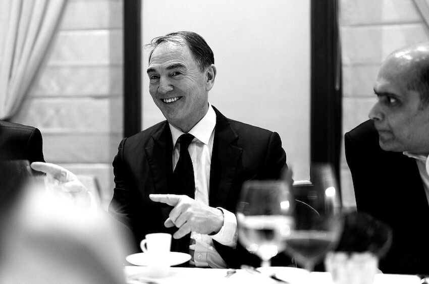 Black and white photo of Alan Parker gesturing warmly and smiling at a dinner event