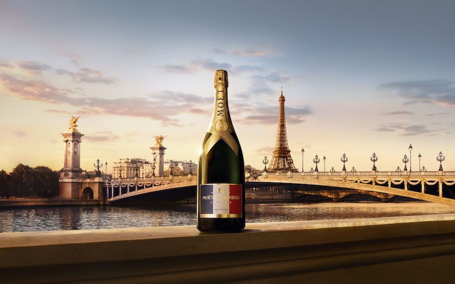 an illustration of a bottle of Moet Chandon on a bridge in Paris overlooking the Eiffel Tower