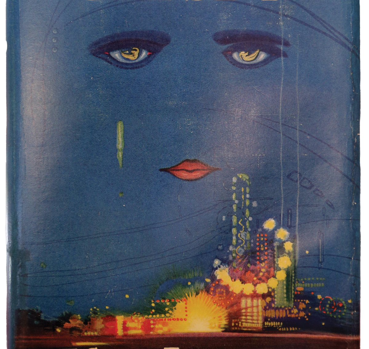 Blue book cover illustration featuring a large disembodied face with golden eyes and red lips floating above a glowing city skyline with bright lights and fireworks-like bursts.