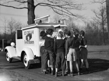 1940s GROUP OF BOYS CROWDING AROUND ICE CREAM MAN AT BACK OF GOOD HUMOR TRUCK
