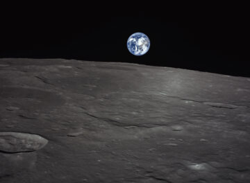 A photograph taken from a robotic lander orbiting the Moon capturing a view of the lunar landscape with Earth on the horizon.