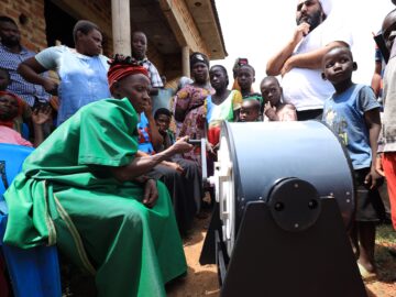 Community members in rural Uganda, hand-cranking the Divya washing machine