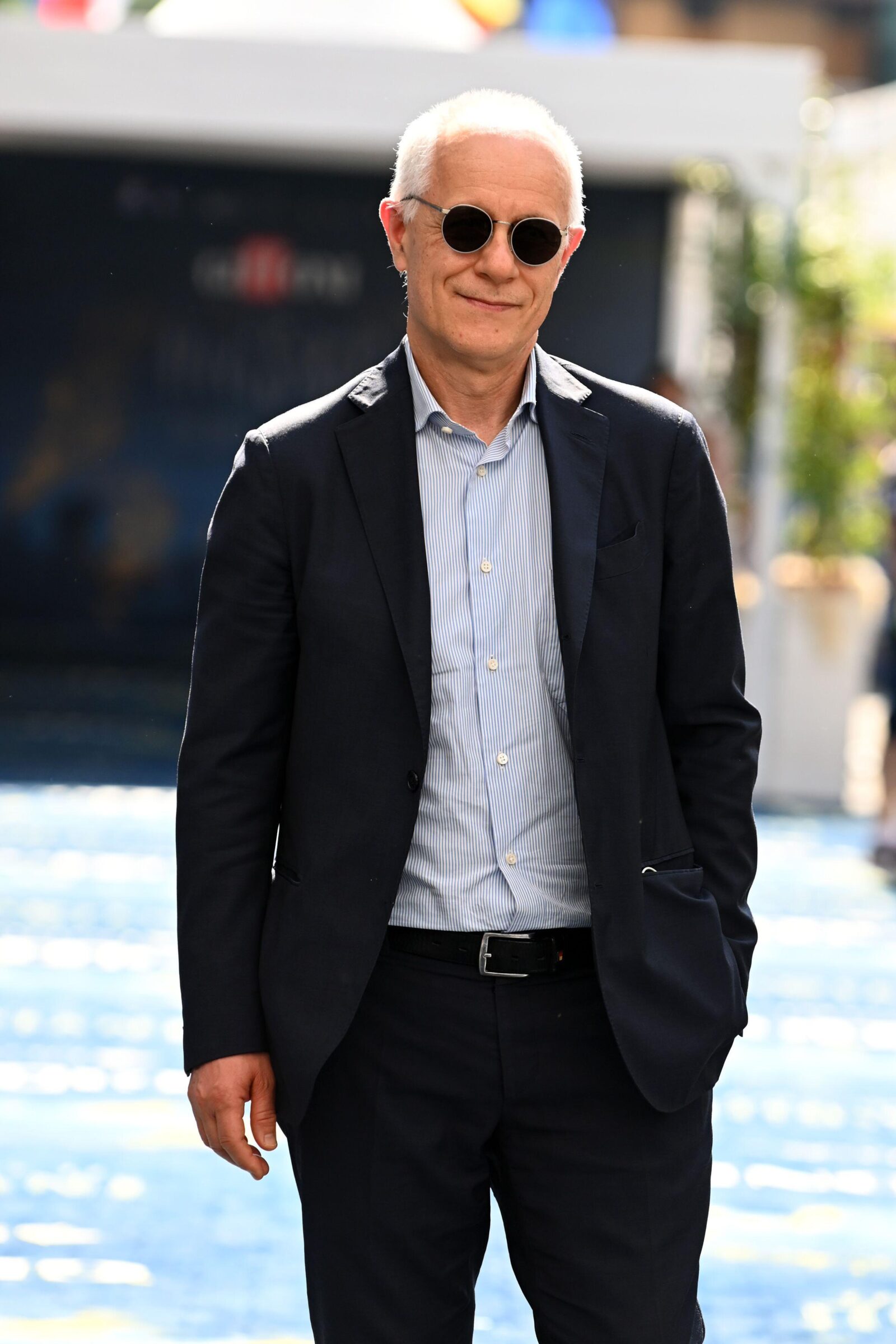 Luciano Fontana attend the blue carpet at the Giffoni Film Festival 2022 on July 28, 2022 in Giffoni Valle Piana, an image of a man in sunglasses and a sport coat walking down a street